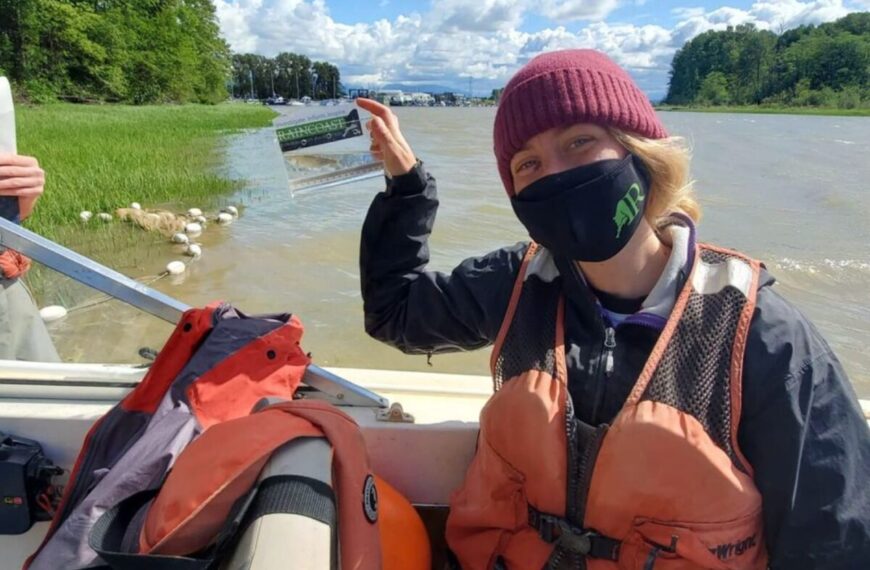 A woman wearing a mask on a boat holding a piece of paper.