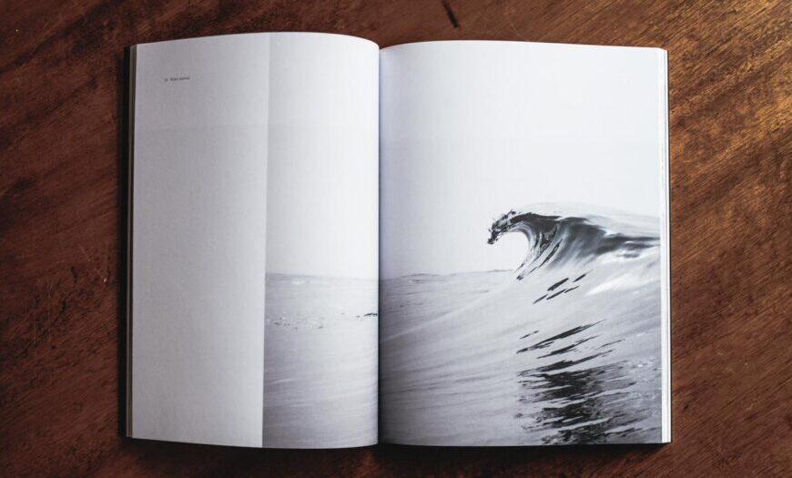 An open book with a photograph of a wave.