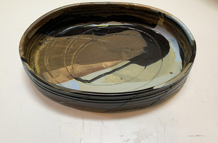 A black and brown bowl sitting on a table.