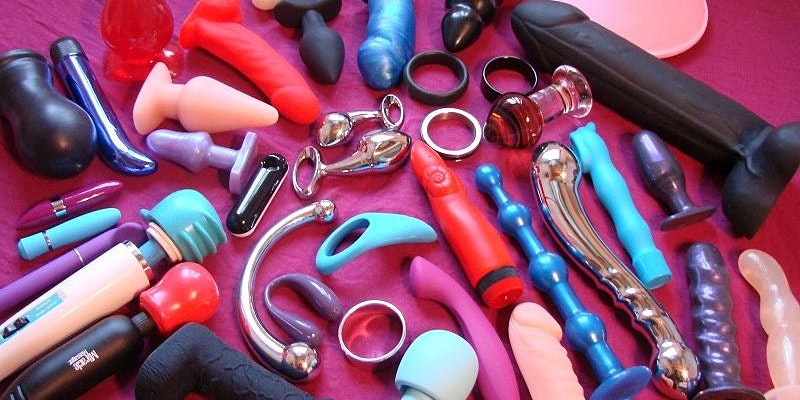 A variety of different types of sex toys are laid out on a table.