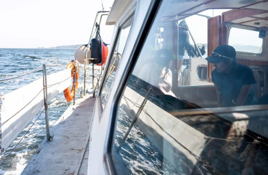 A man looking out the window of a boat.