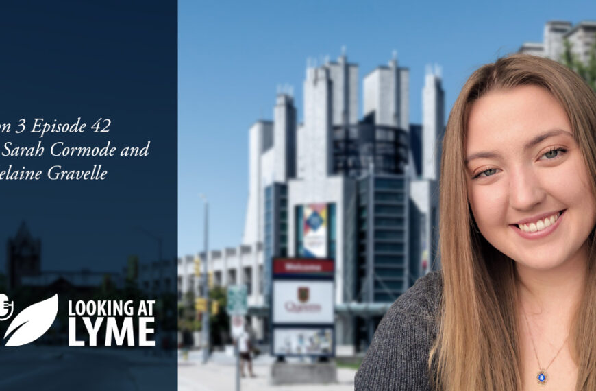 A young woman smiling in front of a building.