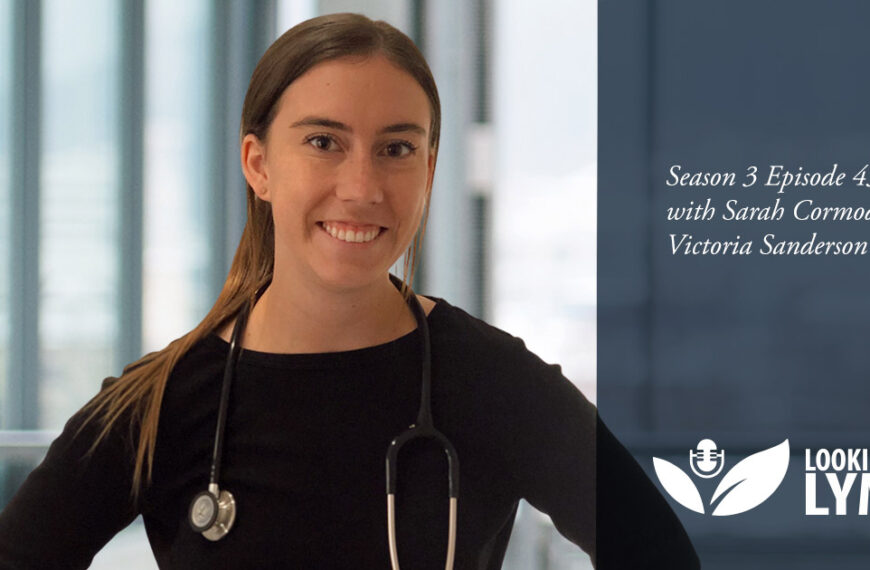 A woman with a stethoscope is standing in front of a white background.