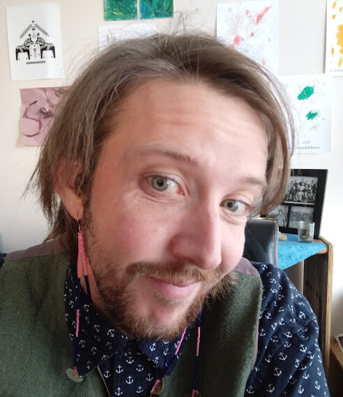 A man with a beard and ear piercings.