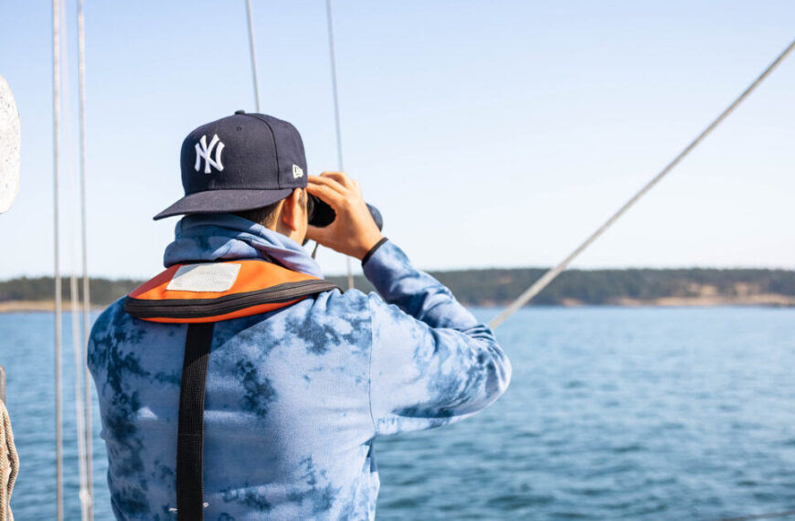 A man wearing a yankees hat on a boat.