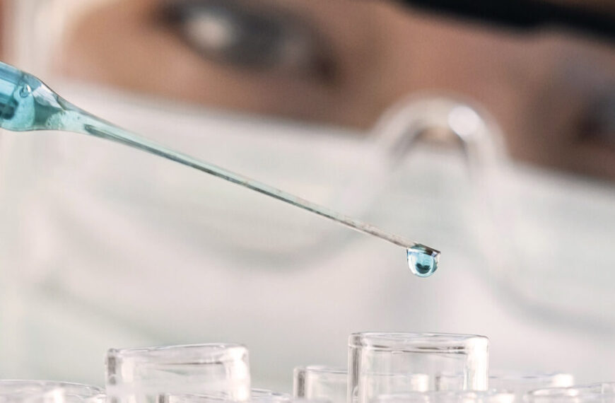 A person holding a syringe in a laboratory.