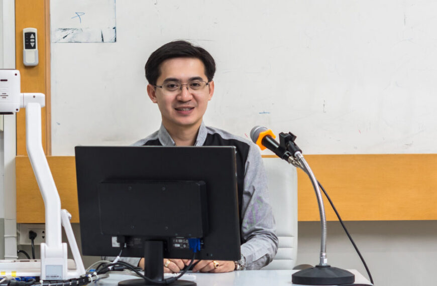 A man sitting at a desk in front of a computer.