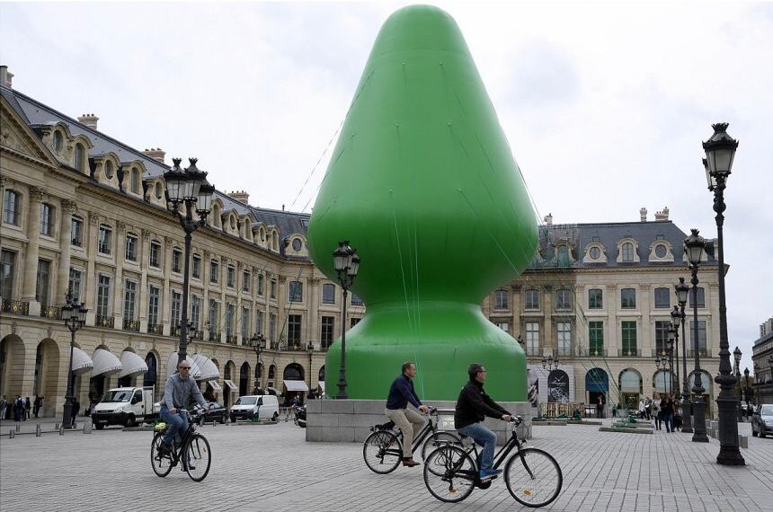 A large green sculpture in front of a building.