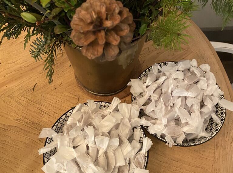 Two plates on a table next to a christmas tree.