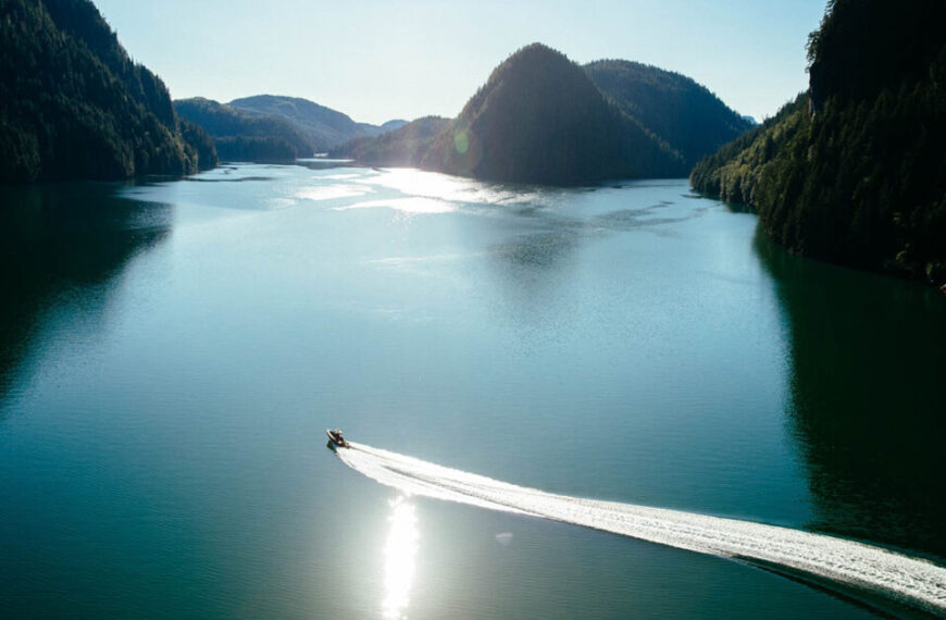 A boat on a lake with mountains in the background.