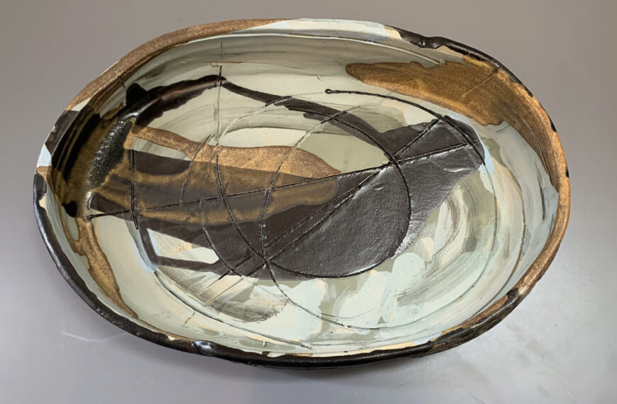 A bowl with a black and gold design on it.