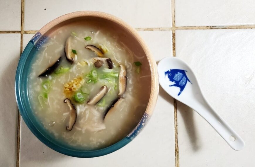A bowl of soup with a spoon next to it.
