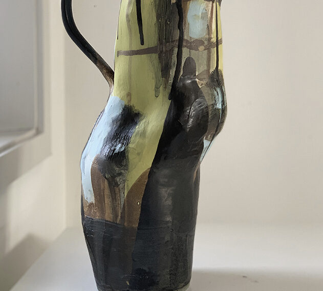 A black and yellow vase sitting on a table.