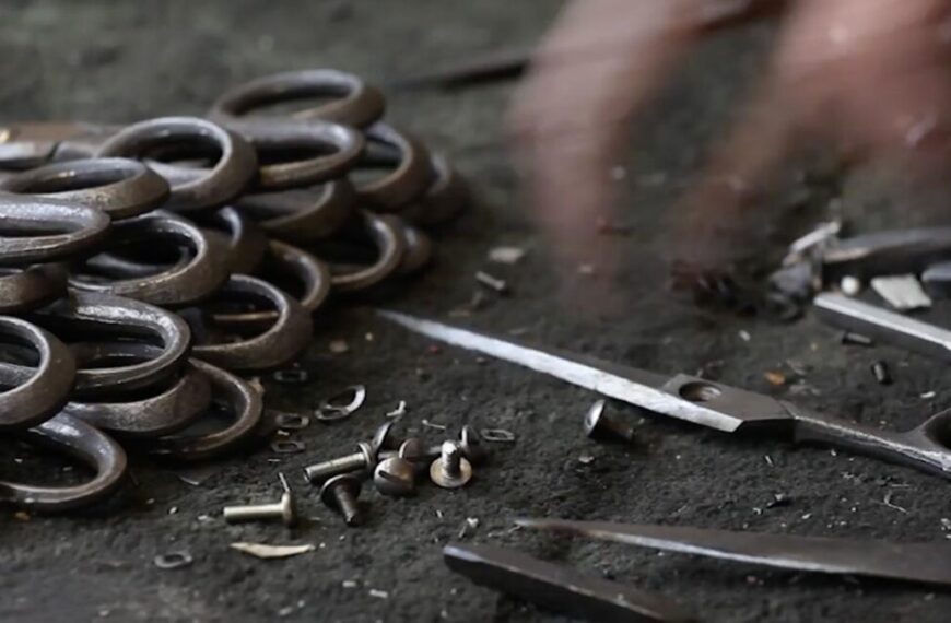 A person is working on a pair of scissors on a table.