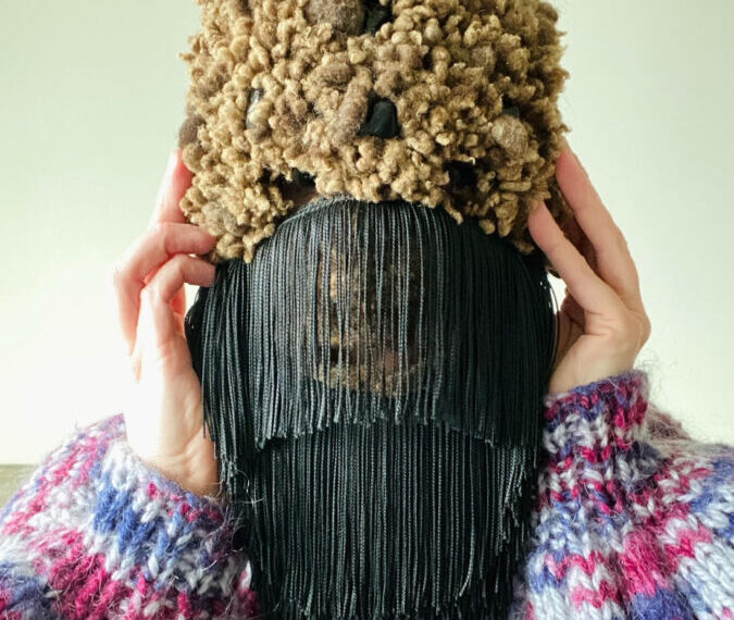 A person wearing a hat with tassels on it.