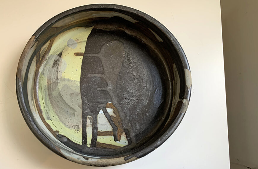 A ceramic bowl hanging on a wall.