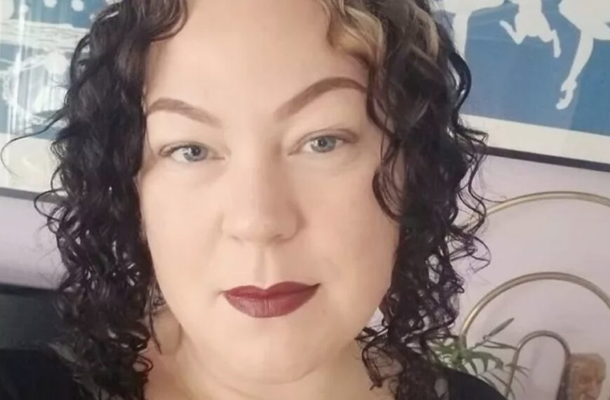 A woman with curly hair is taking a selfie.