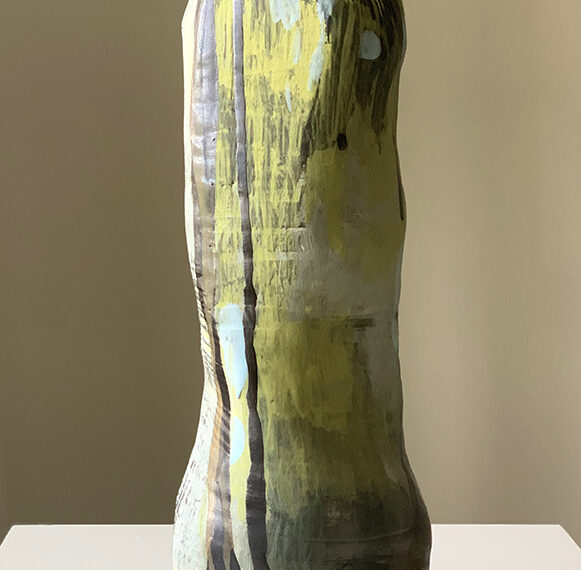 A vase with a green and yellow design on it.