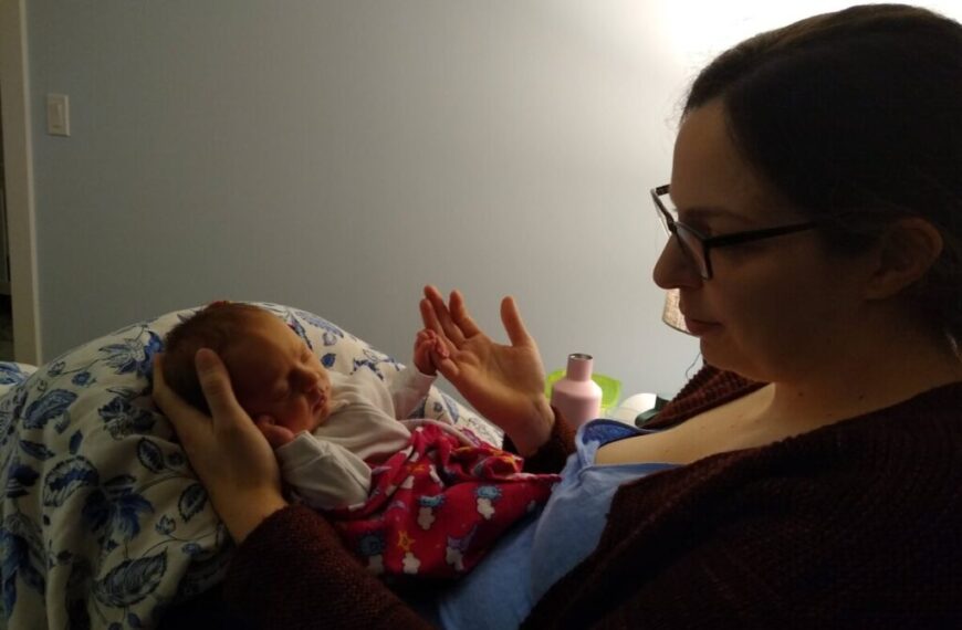 A woman holding a baby in her arms.