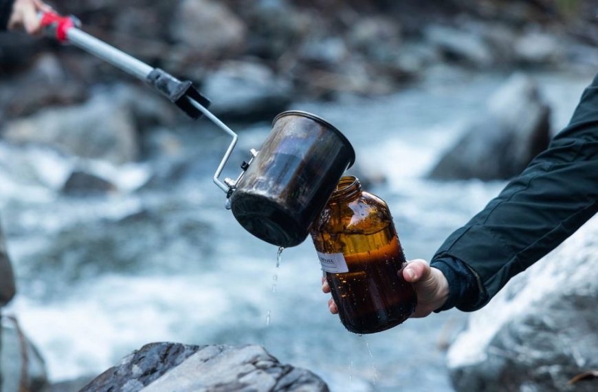 A person is pouring a liquid into a bottle.