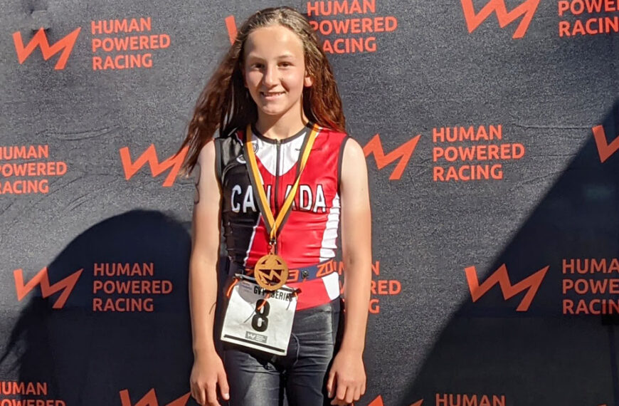 A young girl posing for a photo at the human powered racing event.