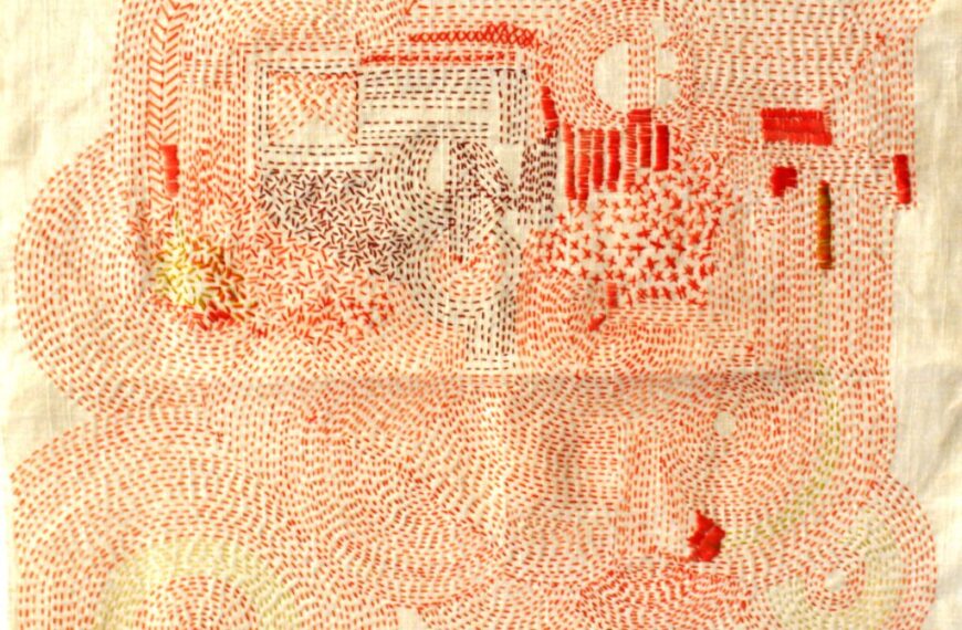 A piece of cloth with red and white embroidery on it.
