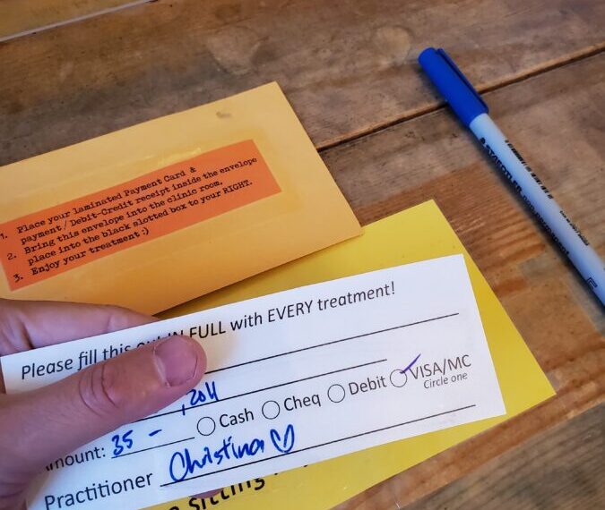 A person holding a check on a table.