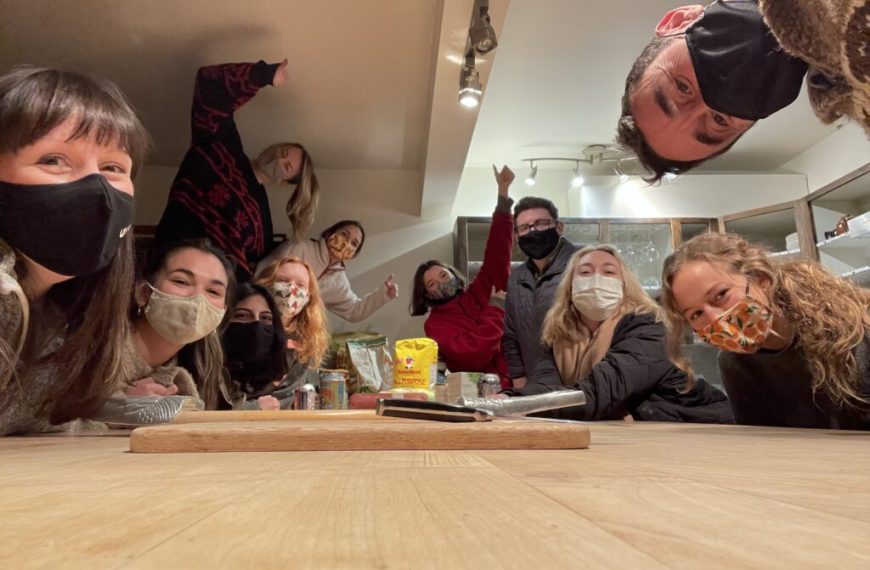 A group of people wearing face masks around a table.