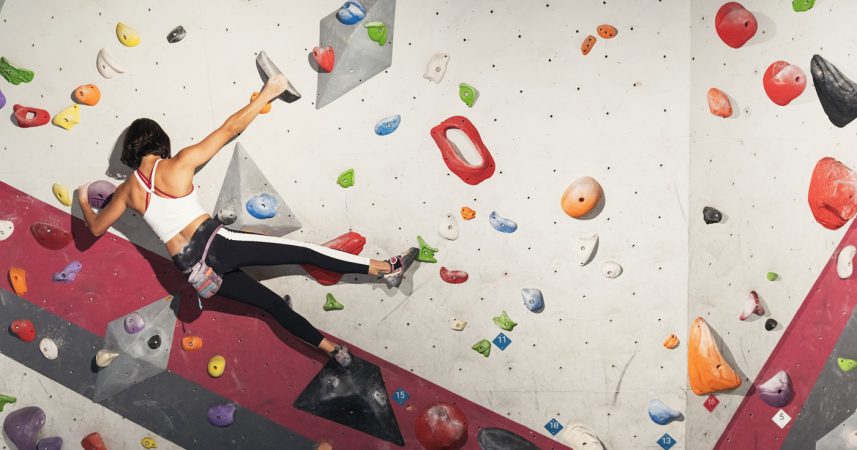A woman is climbing on a climbing wall.