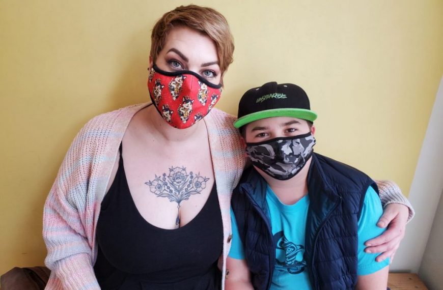 A woman and a boy wearing face masks.