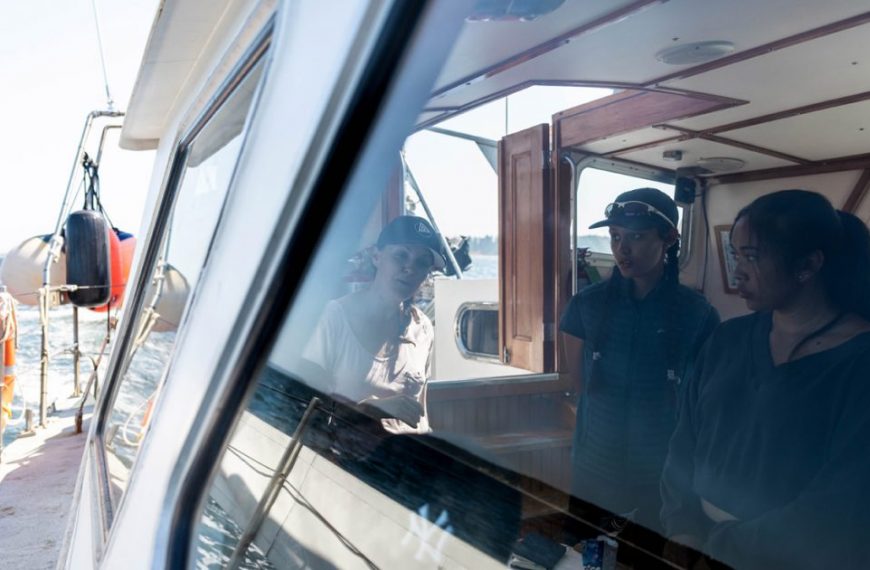 A group of people looking out the window of a boat.