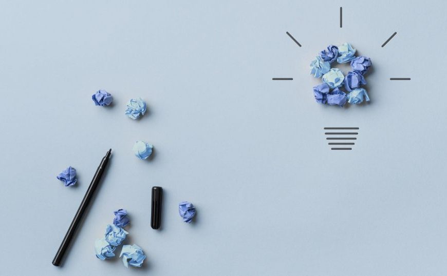 A blue light bulb and pencils on a blue background.