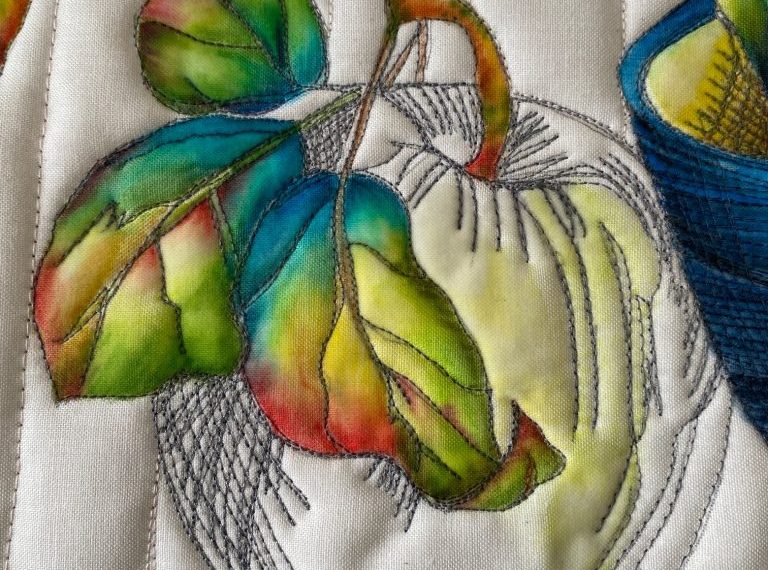 A quilt with apples and leaves on it.