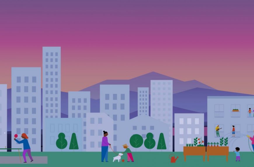 A group of people in a park with buildings in the background.