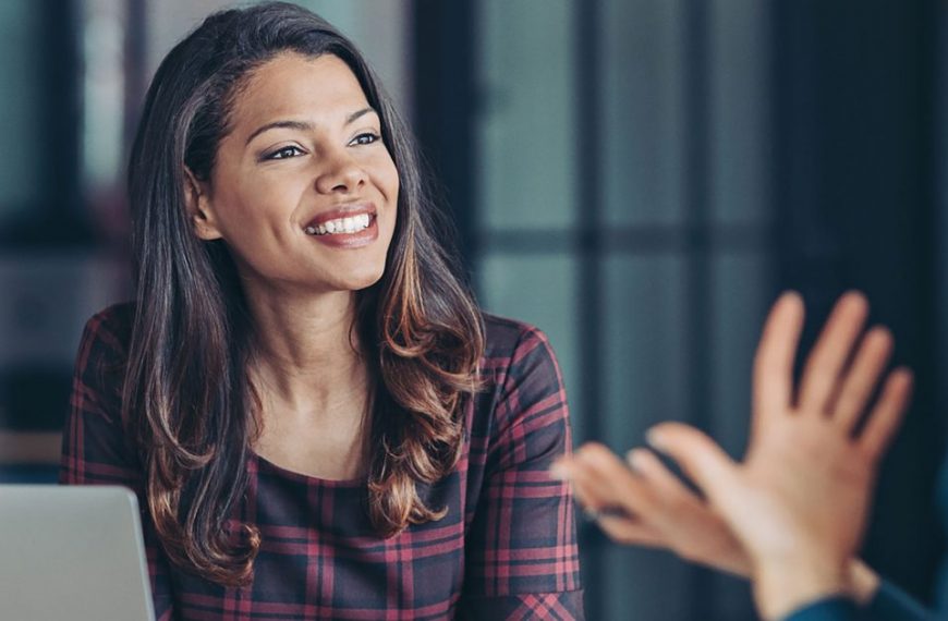 A woman is talking to another woman in an office.