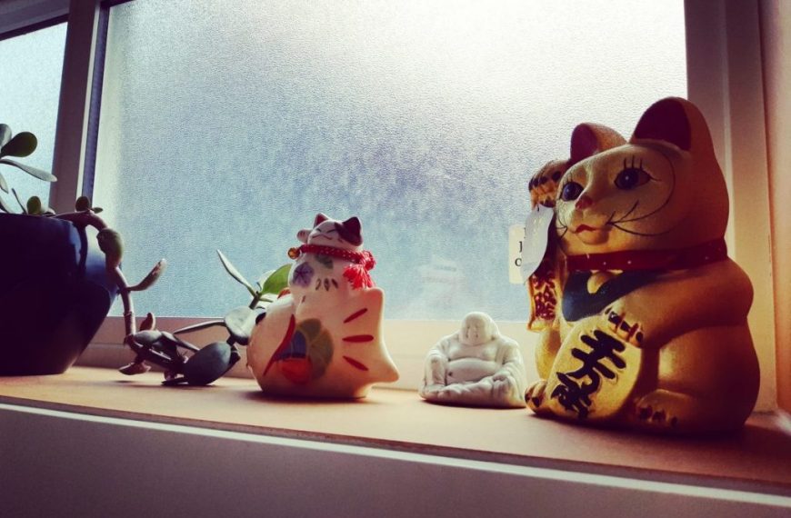 A window sill with a group of figurines and a potted plant.
