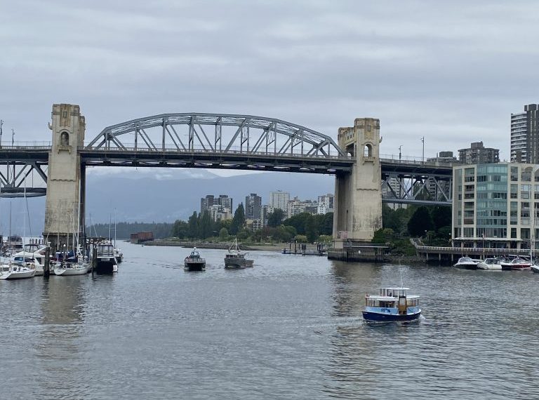 A bridge over a body of water with boats on it.