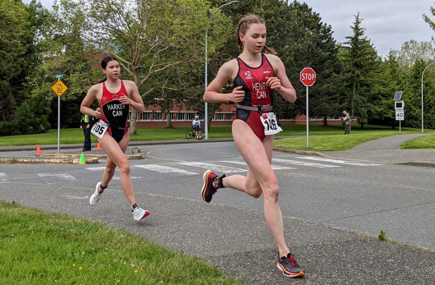Two women running in a race on a street.