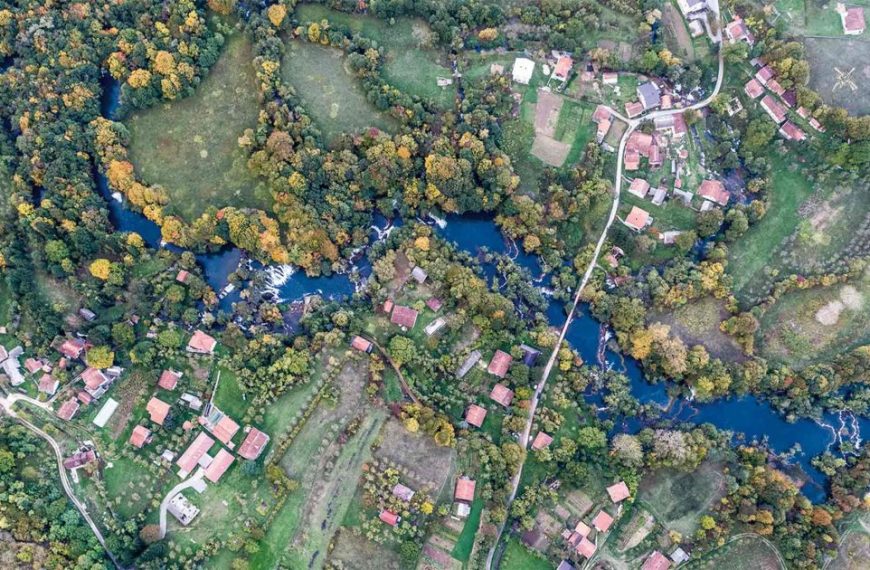 An aerial view of a village and a river.