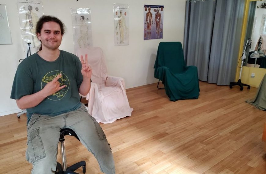 A man sitting on a chair in a room.
