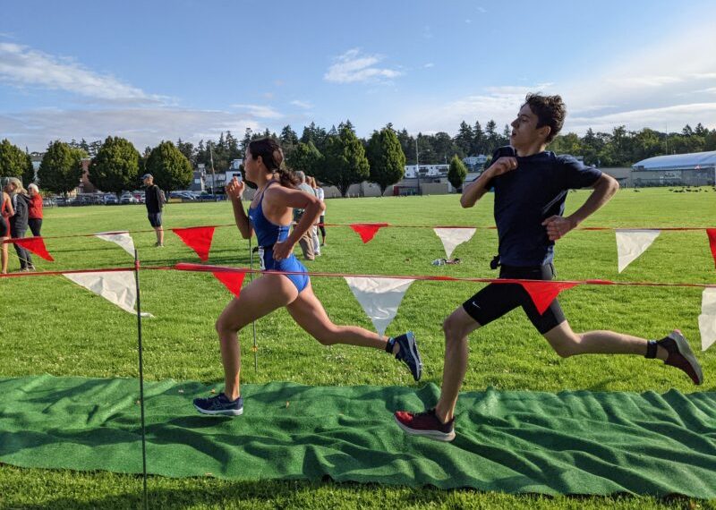 Two people running in a cross country race.