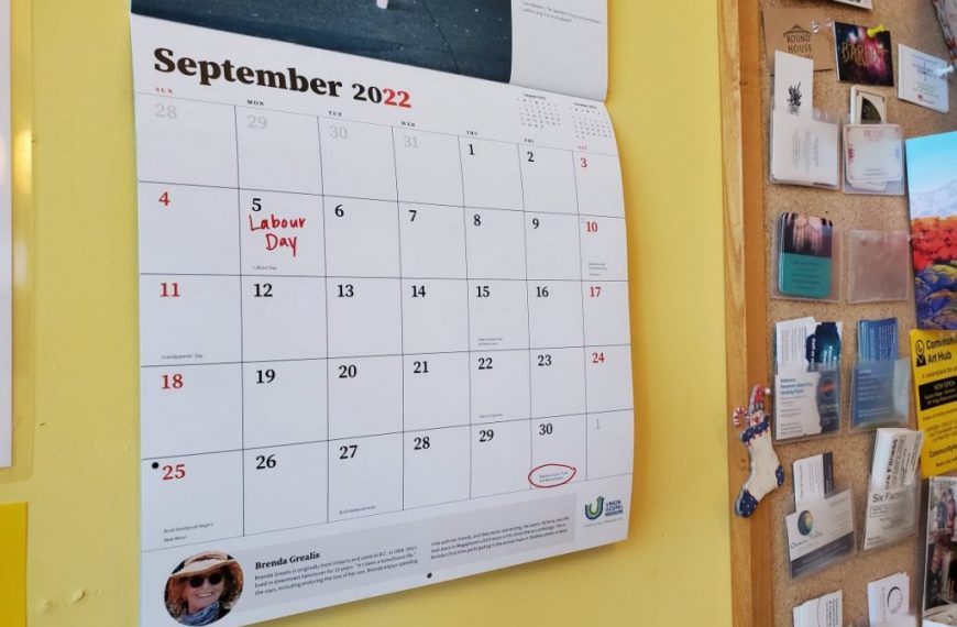 A calendar is on the wall of a room.