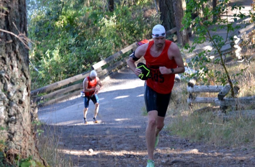 A man is running down a trail.