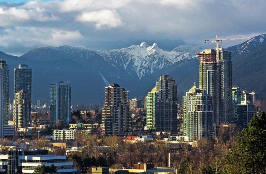 The skyline of vancouver with mountains in the background.