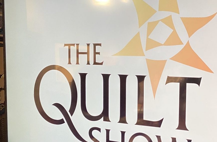 The quilt show logo on a screen.
