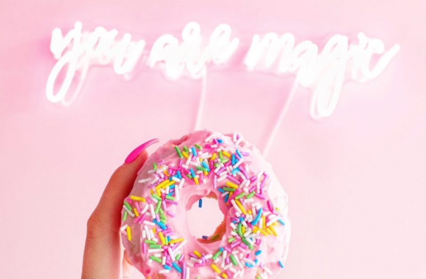 A hand holding a donut with the words you are magic.