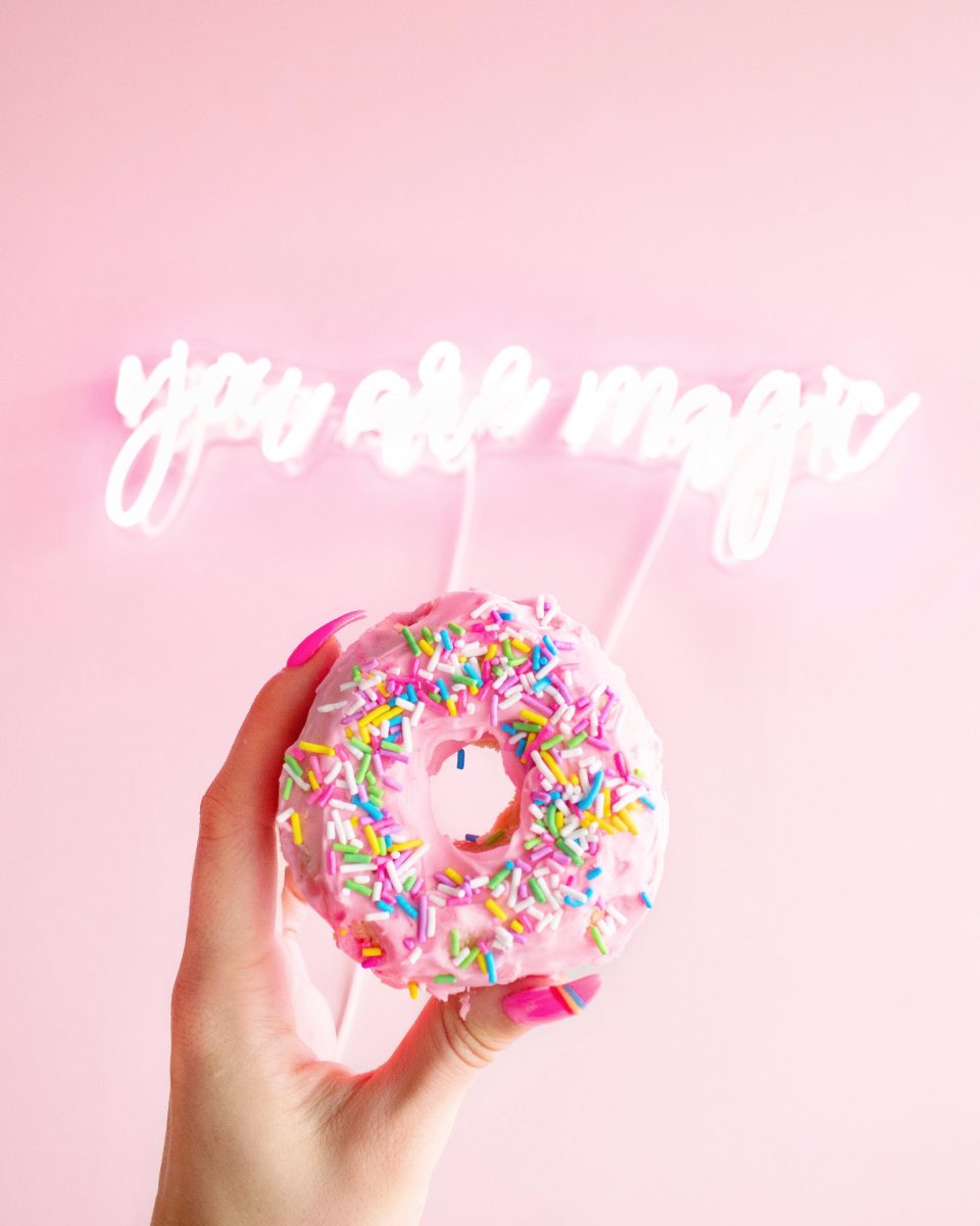 A hand holding a donut with the words you are magic.