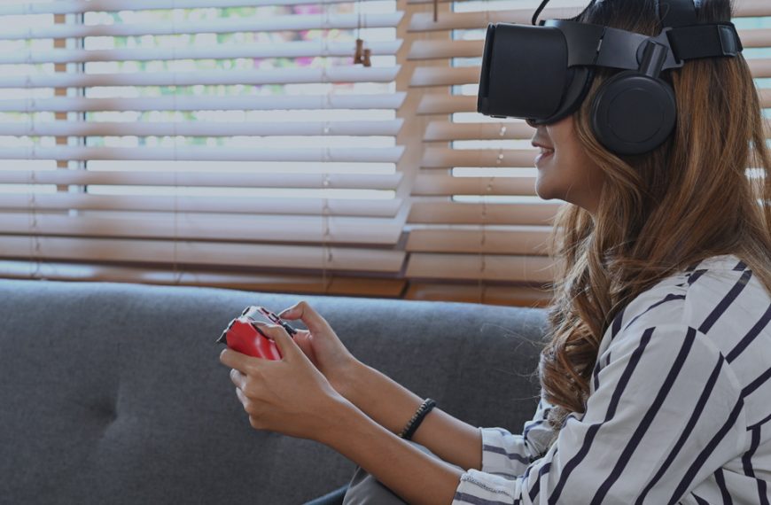 A woman wearing a vr headset while playing a game on a couch.