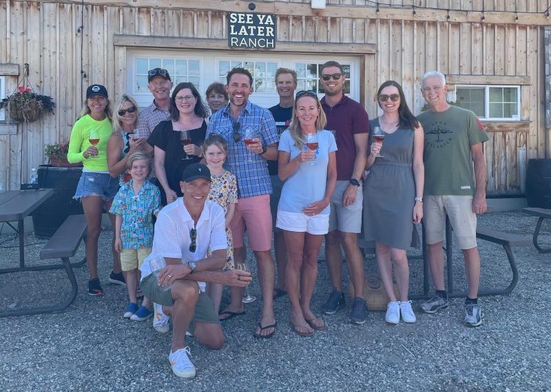 A group of people posing in front of a barn.