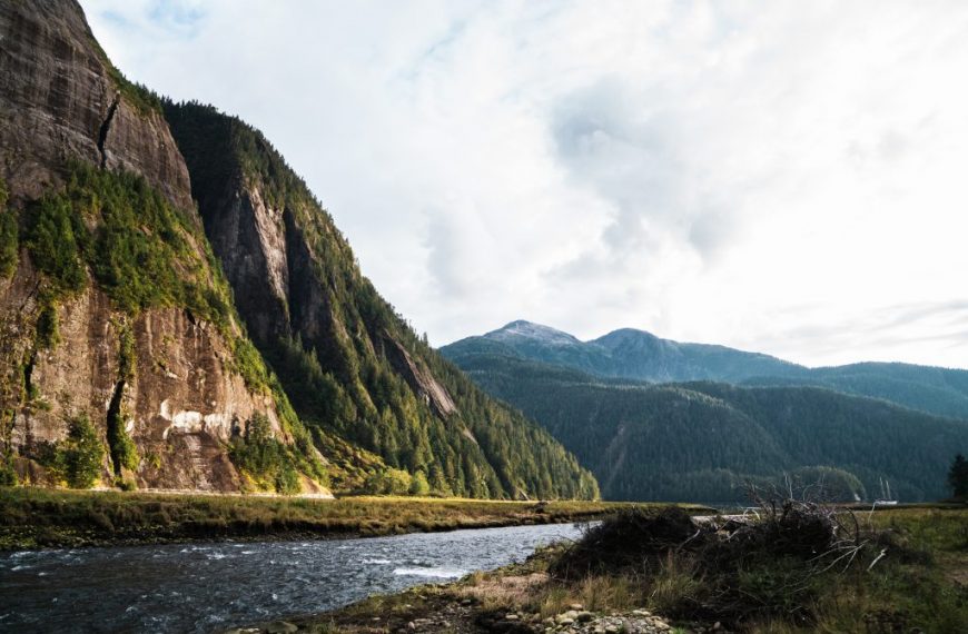 A river runs through a canyon with mountains in the background.